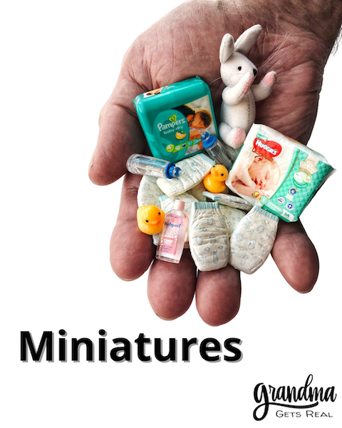 miniature baby things in large man's hand